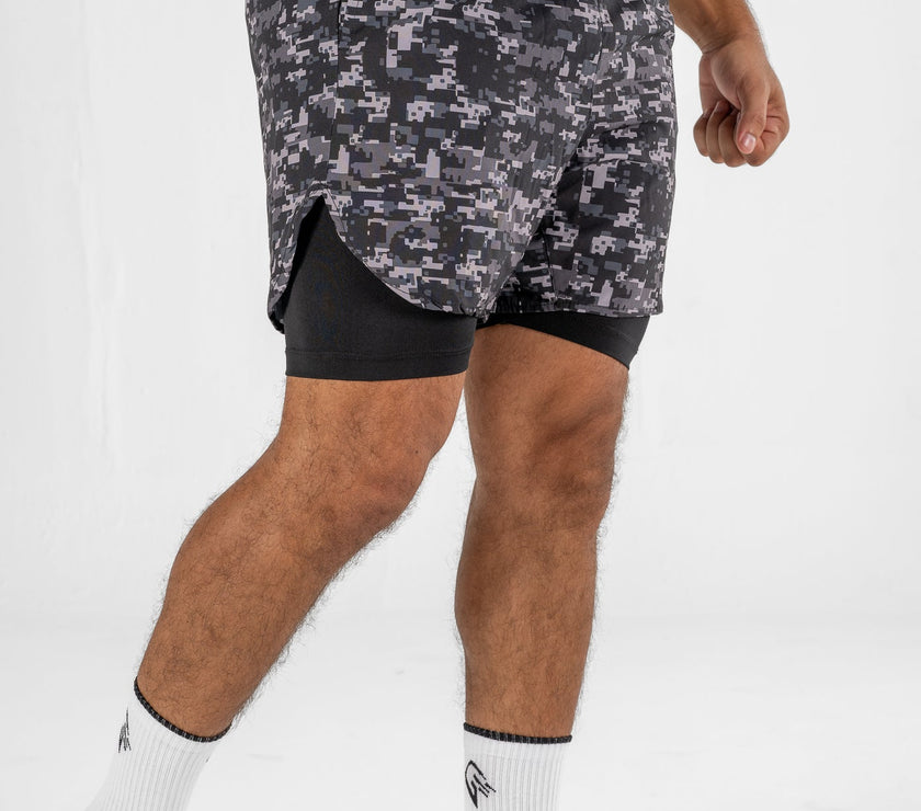 Person wearing camouflage athletic shorts on a white background