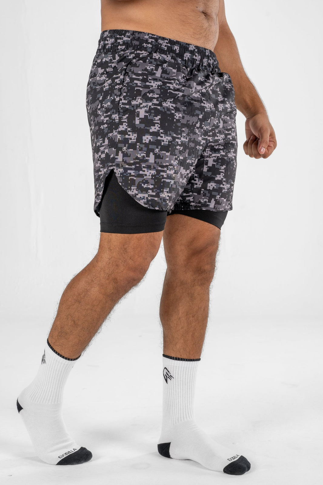 Person wearing camouflage athletic shorts on a white background