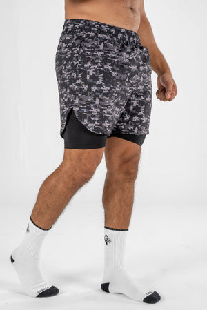 Person wearing camouflage athletic shorts on a white background